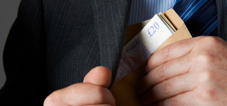 A man puts an envelope of cash in his pocket